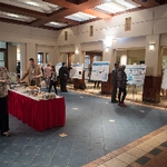 The Graduate Showcase, including many posters, a buffet table, and people moving around the room